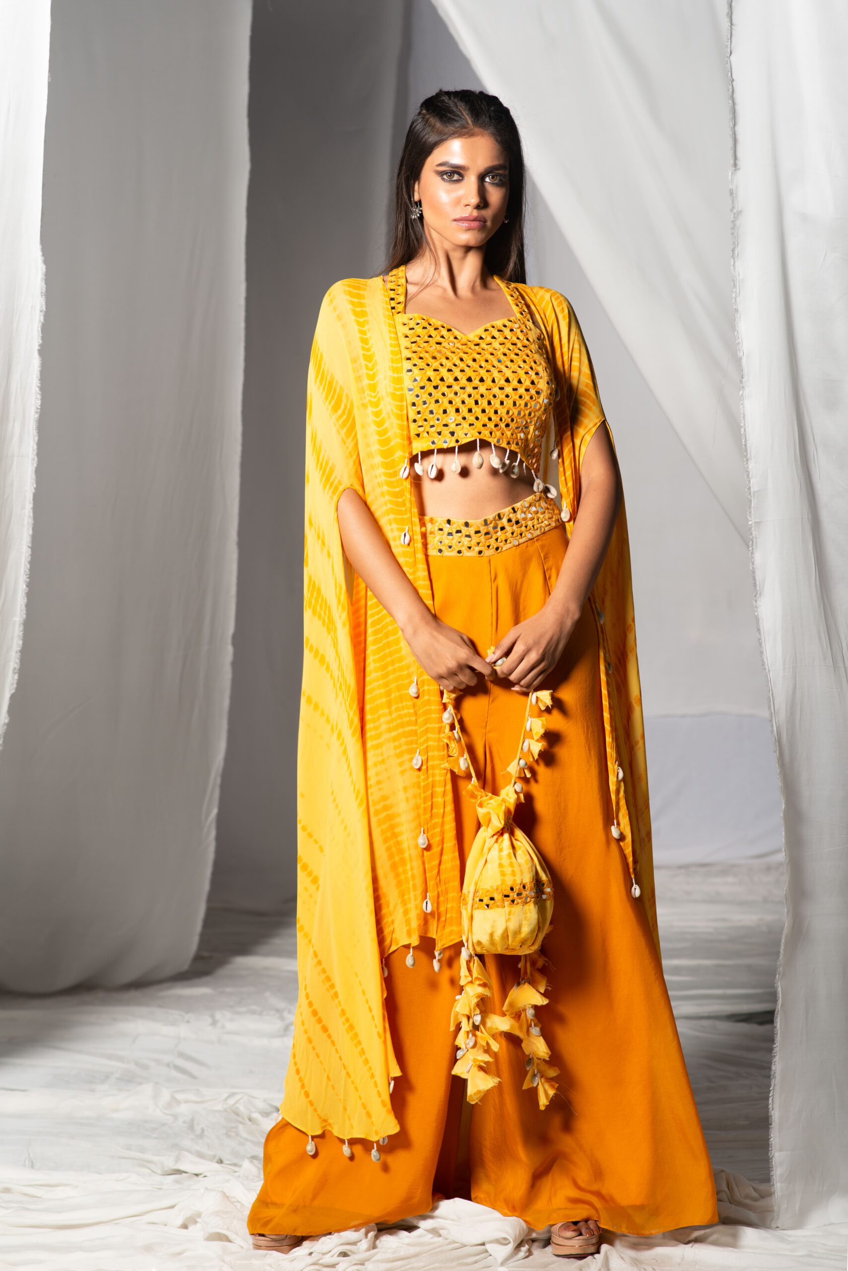 CROP TOP WITH FLARED PANTS AND A LONG CAPE.